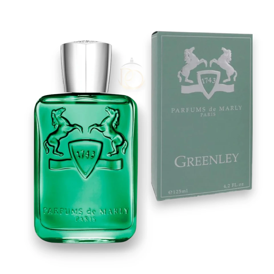 Frasco verde translúcido de Parfums de Marly Greenley rodeado de manzanas frescas y hojas de menta.